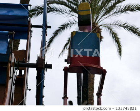 vibrant amusement ride, colorful bucket seat against sky with industrial textures and summer vibe vibrant amusement ride, colorful bucket seat against sky with industrial textures and summer vibe 133745821
