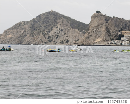 coastal paddlers enjoying calm waters, tourists gather near shoreline with kayaks and serene sky coastal paddlers enjoying calm waters, tourists gather near shoreline with kayaks and serene sky 133745858