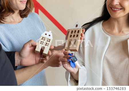 Realtor handing keys to new apartment to young emotional couple. Concept new homes, new beginning. High quality photo Realtor handing keys to new apartment to young emotional couple. Concept new homes, new beginning. High quality photo 133746283