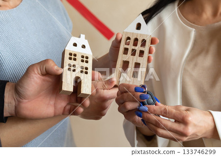 Realtor handing keys to new apartment to young emotional couple. Concept new homes, new beginning. High quality photo Realtor handing keys to new apartment to young emotional couple. Concept new homes, new beginning. High quality photo 133746299