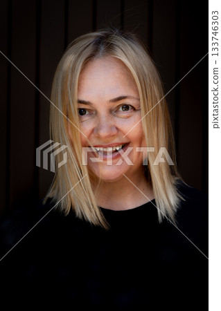 Portrait of cheerful smiling woman on black background. Laughing girl. Emotions of happiness. High quality photo 133746303
