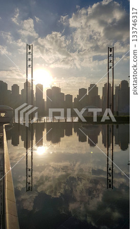 Panoramic view of Business Bay district with reflection in sea in morning. Aerial sky at highest buildings in central Dubai, United Arab Emirates 133746317