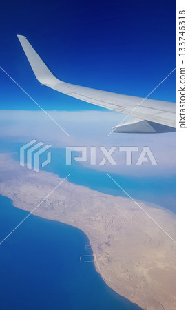 View from the window of plane on blue sky and earth with landscape of desert, sea and canals in Emirates. High quality photo 133746318