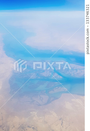 View from the window of plane on blue sky and earth with landscape of desert, sea and canals in Emirates. High quality photo View from the window of plane on blue sky and earth with landscape of desert, sea and canals in Emirates. High quality photo 133746321