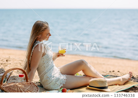 Romantic blonde woman in straw hat having picnic on sea beach. Fresh fruits, juice, cookies and peaches. High quality photo Romantic blonde woman in straw hat having picnic on sea beach. Fresh fruits, juice, cookies and peaches. High quality photo 133746338