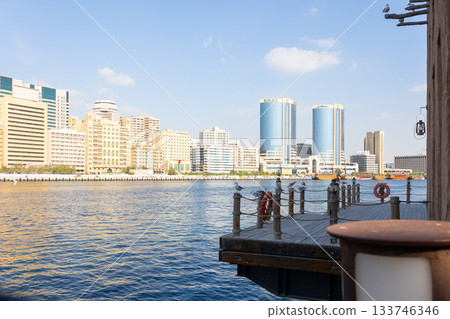 Old town in Al Seef Cultural Historical District. Beautiful view of water, old houses and new ones of Dubai Creek, Dubai, UAE. Taken off hand. High quality photo 133746346