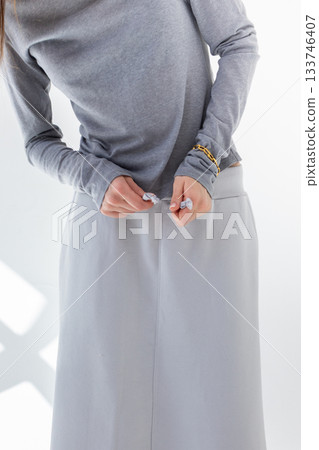 Beautiful woman in gray skirt and T-shirt on white background. Fashionable female style. Studio photography. Vertical photo. High quality photo Beautiful woman in gray skirt and T-shirt on white background. Fashionable female style. Studio photography. Vertical photo. High quality photo 133746407