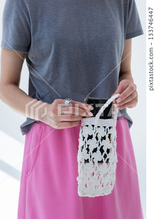 Woman in gray T-shirt and pink skirt holding fashionable white woven bag. Fashion and luxury accessories. Vertical photo. High quality photo Woman in gray T-shirt and pink skirt holding fashionable white woven bag. Fashion and luxury accessories. Vertical photo. High quality photo 133746447
