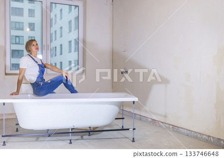 Woman in new apartment with dreams about new life. Bath is in middle of room. Renovation in new apartment. Repair work of home. High quality photo 133746648