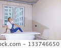 Woman in new apartment with dreams about new life. Bath is in middle of room. Renovation in new apartment. Repair work of home. High quality photo 133746650