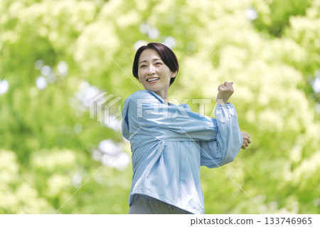一名 40 多歲的女性在戶外進行熱身運動 133746965
