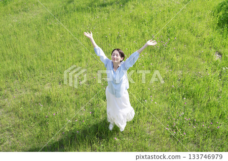 Aerial view of a woman taking a deep breath in the field Aerial view of a woman taking a deep breath in the field 133746979
