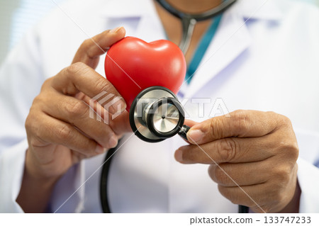 Doctor holding a red heart in hospital ward, healthy strong medical. 133747233