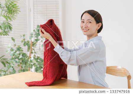 A woman spreading out her red sweater A woman spreading out her red sweater 133747916