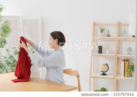 A woman spreading out her red sweater A woman spreading out her red sweater 133747918