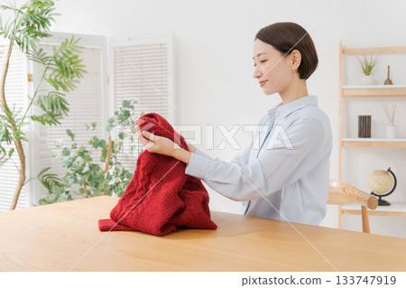 A woman spreading out her red sweater A woman spreading out her red sweater 133747919