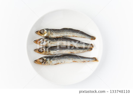 Grilled dried urume (round dried fish) on a plate on a white background 133748110