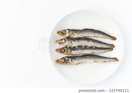 Grilled dried urume (round dried fish) on a plate on a white background 133748111