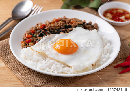 Thai food, Stir fried holy basil with minced pork with cooked rice and fried egg on top Thai food, Stir fried holy basil with minced pork with cooked rice and fried egg on top 133748146