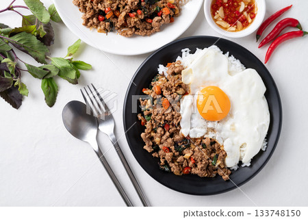 Thai food, Stir fried holy basil with minced pork with cooked rice and fried egg on top Thai food, Stir fried holy basil with minced pork with cooked rice and fried egg on top 133748150