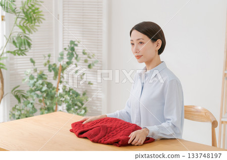 A woman spreading out her red sweater 133748197