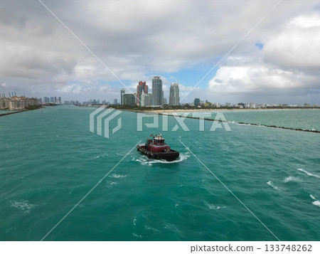 Tugboat leading to port of Miami. Tugboat sailing in sea. Boat transport. Sea vessel transportation. Miami port 133748262