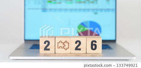 2026 year block with jigsaw puzzle icon against laptop computer. Business Process, Team, teamwork, Goal, mission, Resolution, strategy, plan, Action, partnership, and New Year start 133749921