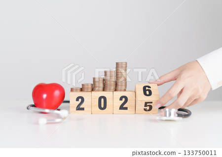 Happy New Year 2026 with doctor Stethoscope, coins stack and red heart on table. health care, Money saving, Goal, Resolution, health Insurance, Wellness and medical concept 133750011