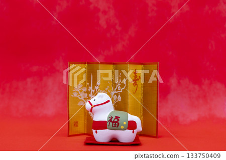 A Japanese-style image of the Year of the Horse zodiac figurine and gold folding screen, with a red background representing the New Year A Japanese-style image of the Year of the Horse zodiac figurine and gold folding screen, with a red background representing the New Year 133750409
