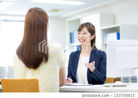 Business woman serving customers at the counter 133750813