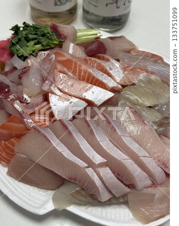 Fresh and delicate sashimi slices, beautifully presented with vibrant colors and perfect cuts. This traditional Japanese delicacy highlights the pure flavors of premium seafood. 133751099