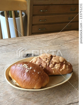 Golden brown salt bread with a soft, fluffy interior and a perfectly crisp crust, lightly sprinkled with coarse salt for a savory touch. A simple yet satisfying treat for any occasion. 133751231