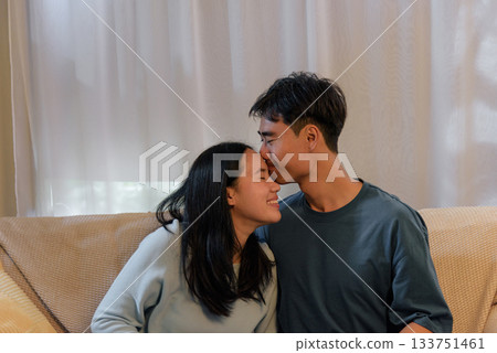 Young happy couple in love, man kissing woman forehead, romantic valentine day scene, showing tender affection and deep intimacy, sharing cozy moment together, truly special day for sweethearts. Young happy couple in love, man kissing woman forehead, romantic valentine day scene, showing tender affection and deep intimacy, sharing cozy moment together, truly special day for sweethearts. 133751461
