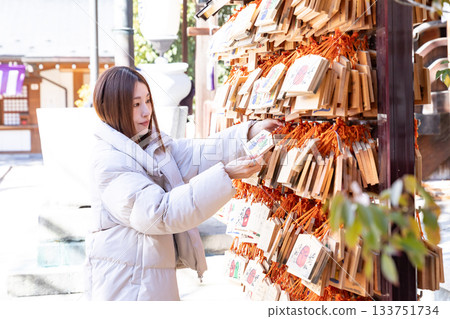 一位婦女正在繫上一塊祈願牌 一位婦女正在繫上一塊祈願牌 133751734