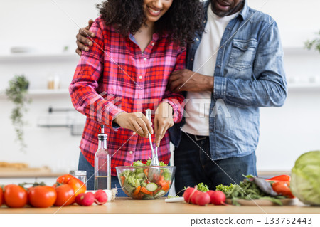 A smiling couple prepares a fresh salad in a bright kitchen, enjoying a moment of togetherness and healthy eating. A smiling couple prepares a fresh salad in a bright kitchen, enjoying a moment of togetherness and healthy eating. 133752443