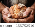 A close-up shot capturing seasoned hands cradling freshly baked bread, symbolizing tradition, craftsmanship, and the simple comforts of home-cooked nourishment. 133752510