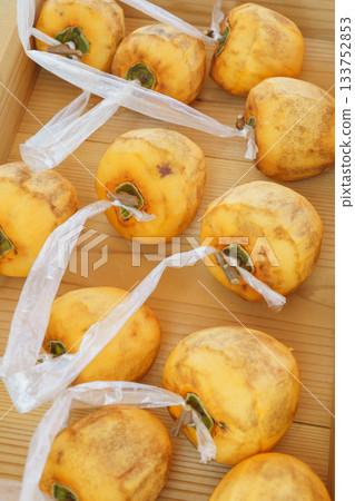 製作柿餅：將樹枝保持 T 字形，並將繩子綁在去皮的柿子上。 133752853