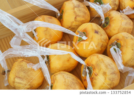 Making dried persimmons: Leave the branch in a T-shape and attach string to the peeled persimmon. 133752854