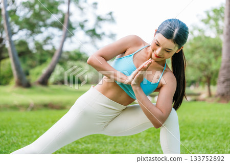 Asian woman practicing yoga outdoors in a peaceful green park Asian woman practicing yoga outdoors in a peaceful green park 133752892