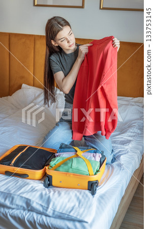 Woman packing clothes for travel trip preparing suitcase Woman packing clothes for travel trip preparing suitcase 133753145