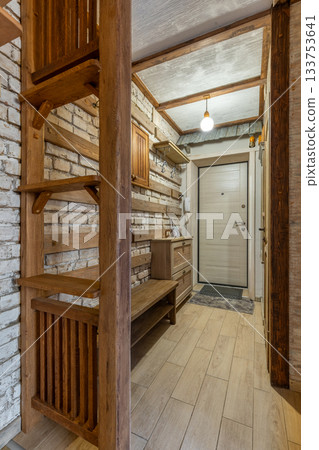 Rustic Wooden Hallway with Brick Wall and Warm Lighting 133753641