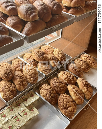 Beautiful and delicious pastries displayed in a bakery, with colorful glazes, delicate toppings, and tempting textures. Offering a perfect visual feast of sweetness and artisanal charm. 133754086