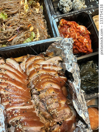 Jokbal, a Korean dish of braised pork hock, slow-cooked in a rich, savory sauce with soy, garlic, and spices. Tender and flavorful, it’s often served with lettuce wraps, garlic, and ssamjang 133754138