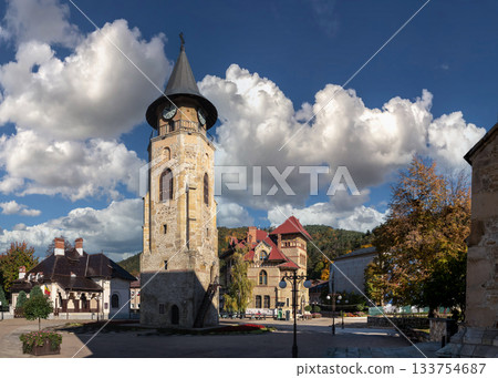 Medieval clock tower rises dramatically under cloudy blue sky Piatra Neamt Medieval clock tower rises dramatically under cloudy blue sky Piatra Neamt 133754687