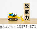 A bulldozer and letter blocks symbolizing reform power 133754871