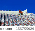 Red tiled roofs and simple shisa lions against the blue sky (Okinawa) 133755029