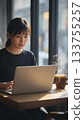 young woman working on laptop in a cafe 133755257
