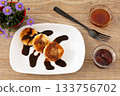 Curd fritters with chocolate, strawberry jam and honey. 133756702