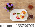 Curd fritters with sour cream, raspberries, strawberry jam and honey. 133756705