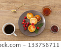 Cup of coffee and curd fritters with raspberries on the wooden background. 133756711